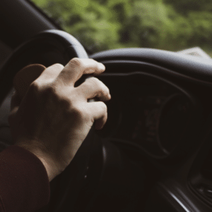Hand on a steering wheel driving a car